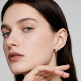 Close-up of Hermin's Everyday Silver Twist Huggies - Paris in sterling silver with rhodium finish, crafted for elegance and durability