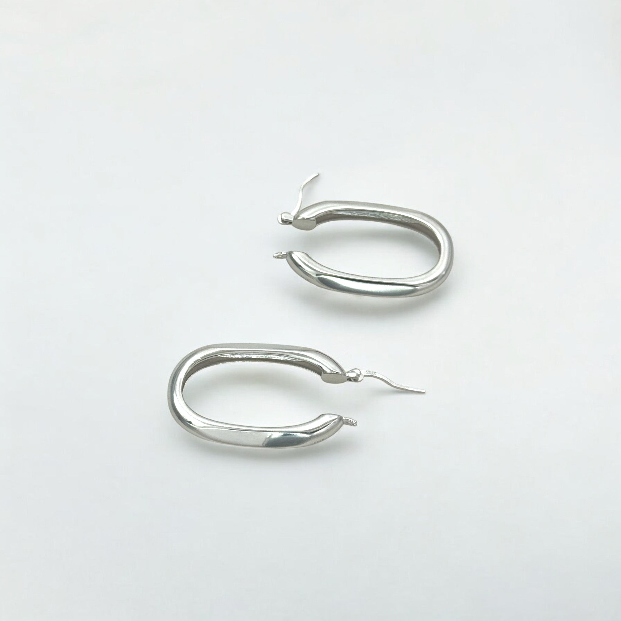 Close-up of Hermin's Classic Statement Oval Silver Hoops - Milan in sterling silver with rhodium finish, crafted for elegance and durability