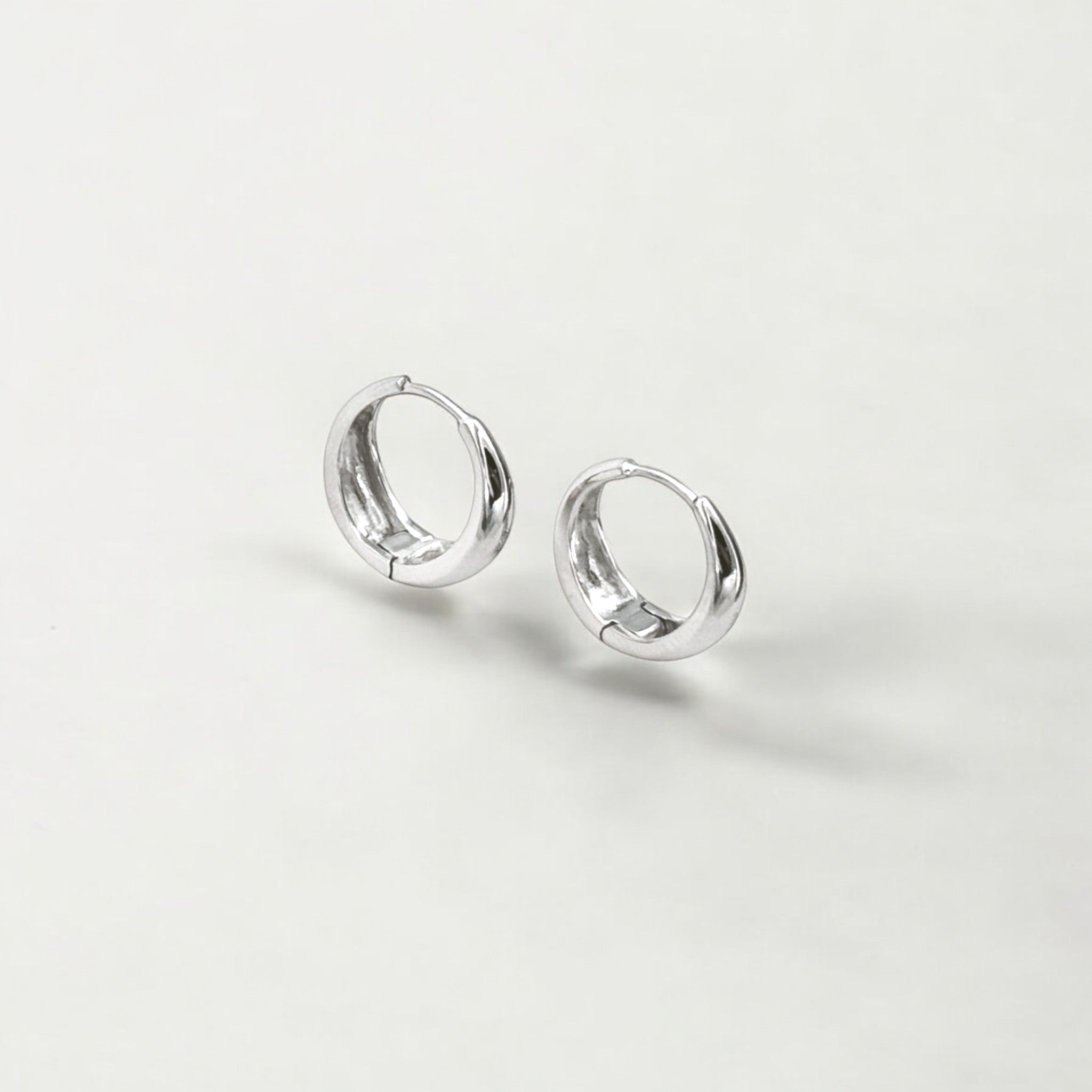 Eclipse Silver Dome Huggie Hoops made from sterling silver with rhodium finish, minimalist design by Hermin Jewelry
