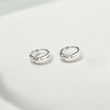 Close-up of Hermin's Eclipse Silver Dome Huggie Hoops in sterling silver with rhodium finish, crafted for elegance and durability