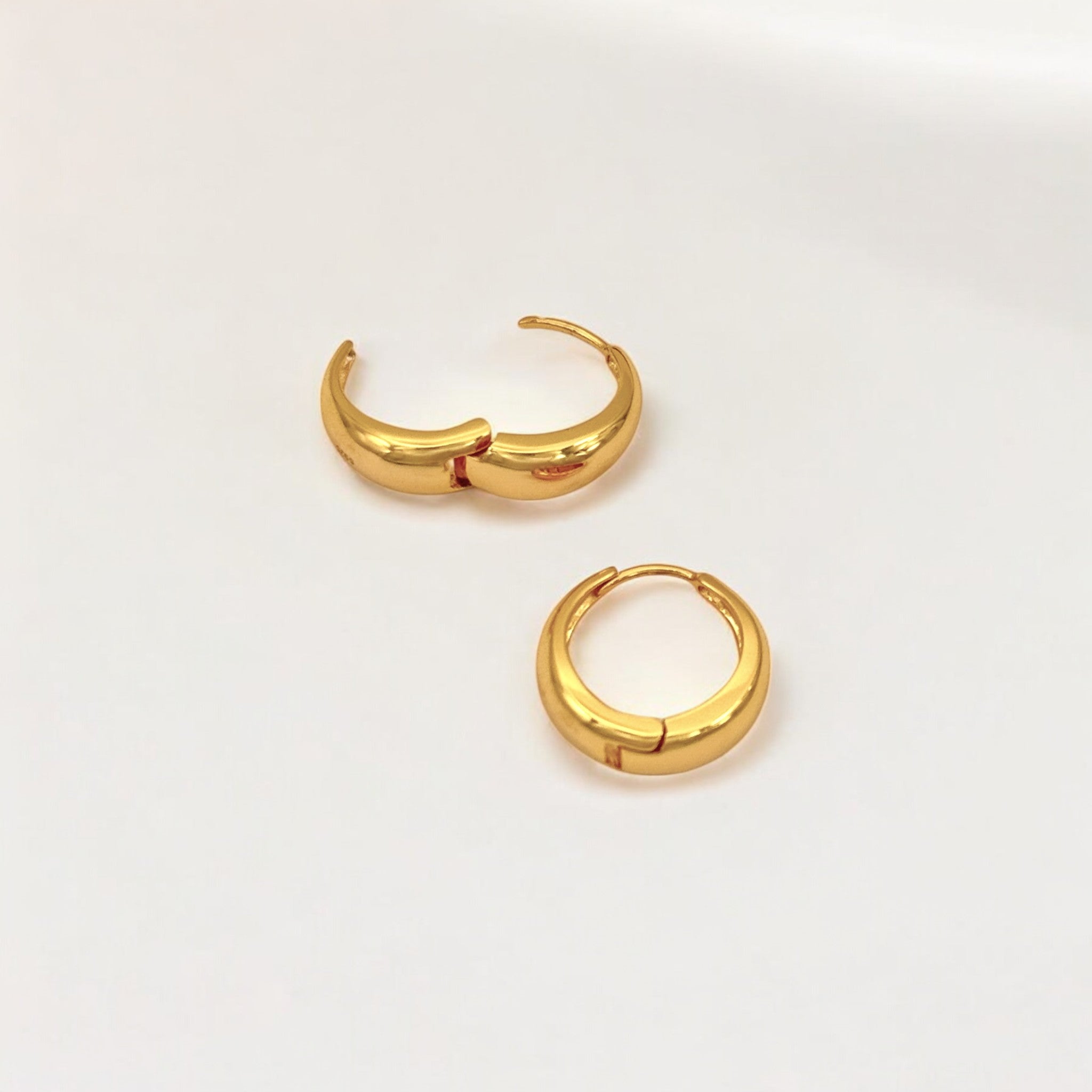 Close-up of Hermin's Eclipse Gold Dome Huggie Hoops in 18k gold vermeil over sterling silver, crafted for elegance and durability