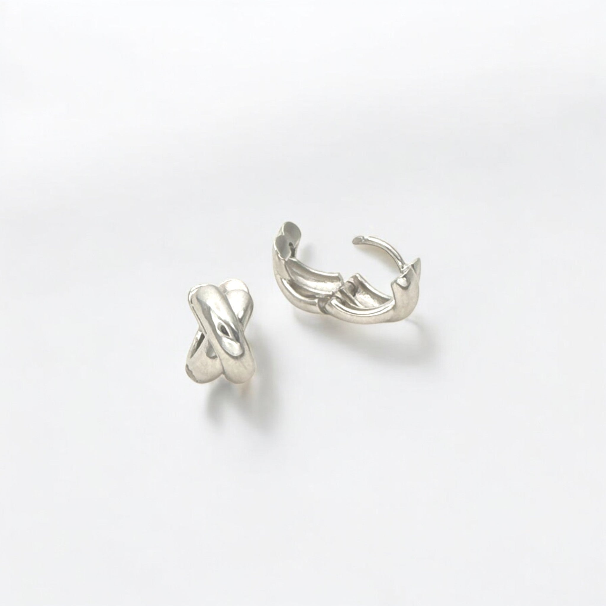 Close-up of Hermin's Everyday Silver Twist Huggies - Paris in sterling silver with rhodium finish, crafted for elegance and durability
