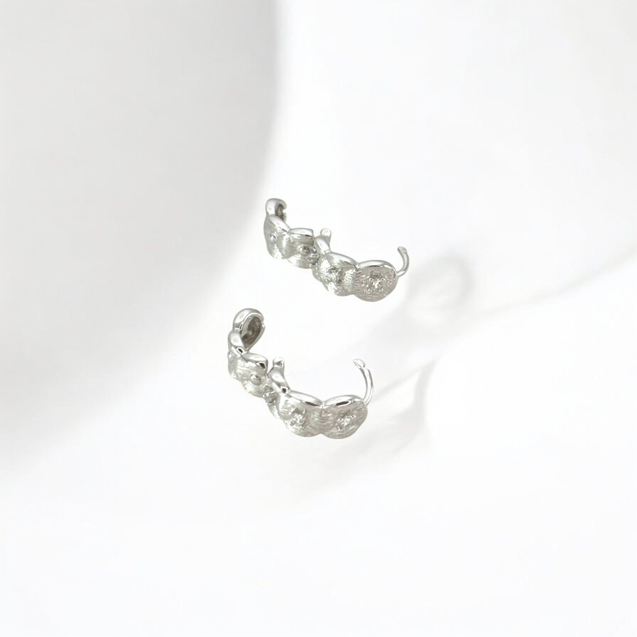 Close-up of Hermin's Tulle Textured Silver Woven Sparkle Huggie Hoops in sterling silver with rhodium finish, crafted for elegance and durability