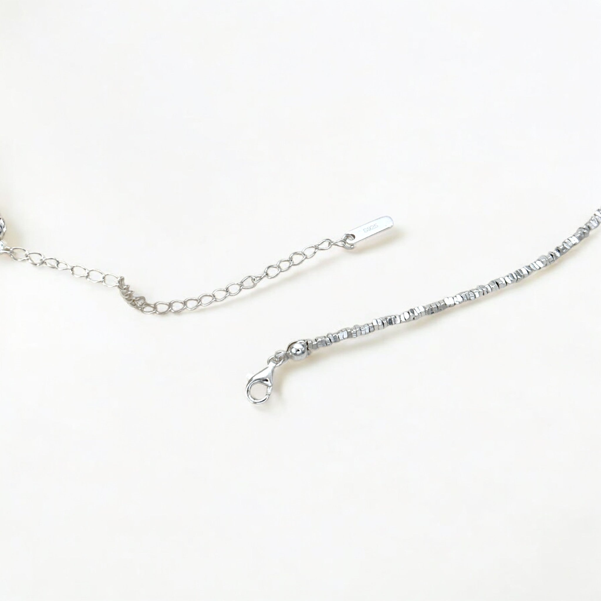 Close-up of Hermin's Faceted Silver Bead Necklace - Gleam in sterling silver with rhodium finish, crafted for elegance and durability