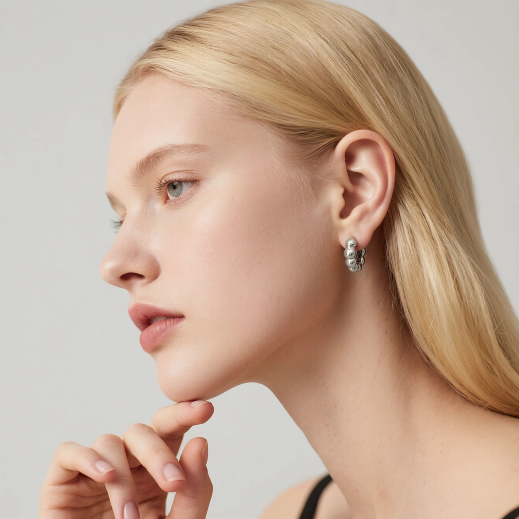 Model wearing hypoallergenic silver vermeil beaded huggie hoop earrings
