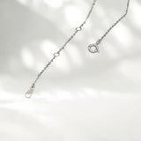 Silver necklace with a clasp on a light gray background