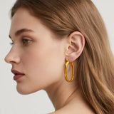 Model wearing hypoallergenic gold vermeil classic statement oval hoop earrings
