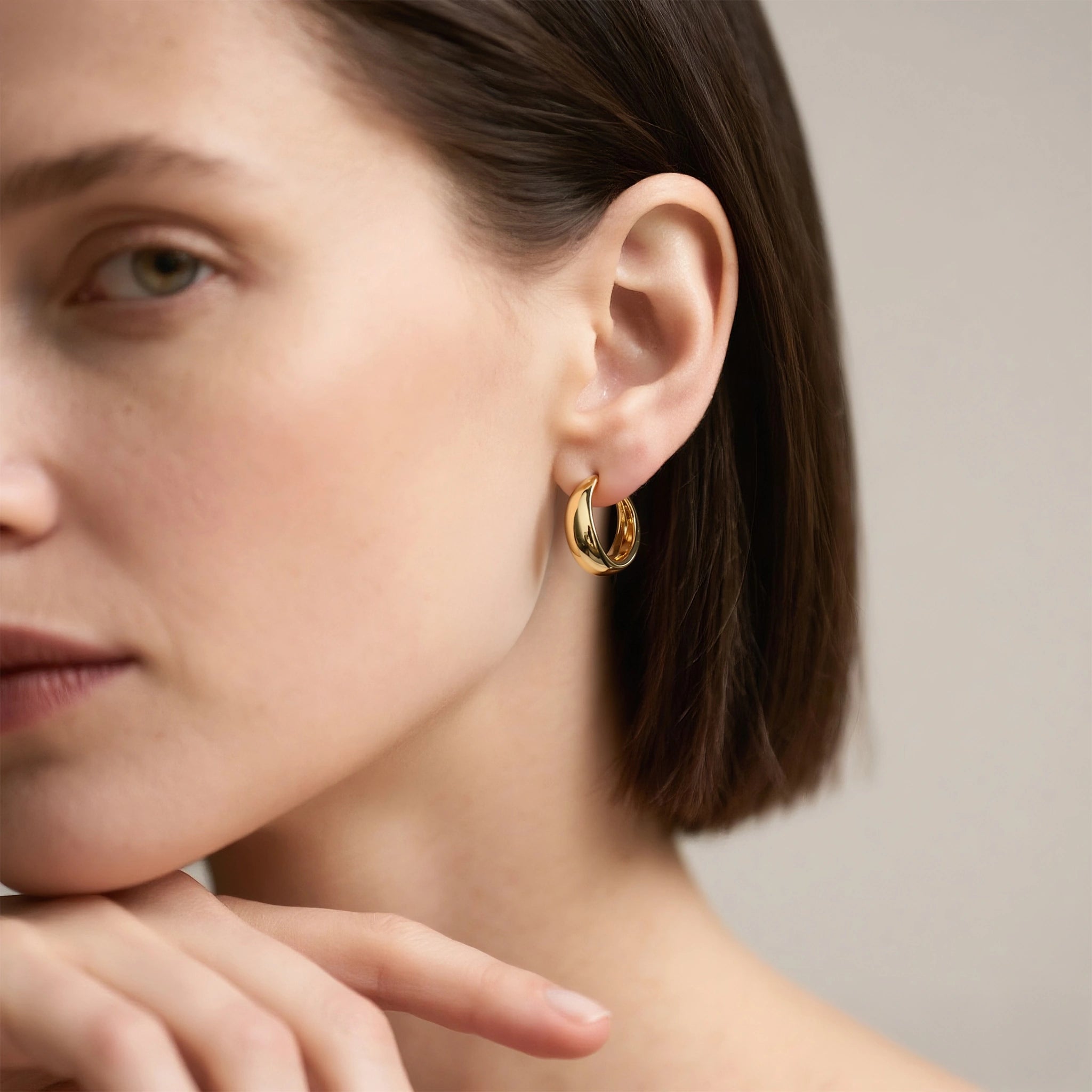 Model wearing hypoallergenic gold vermeil eclipse dome huggie hoop earrings
