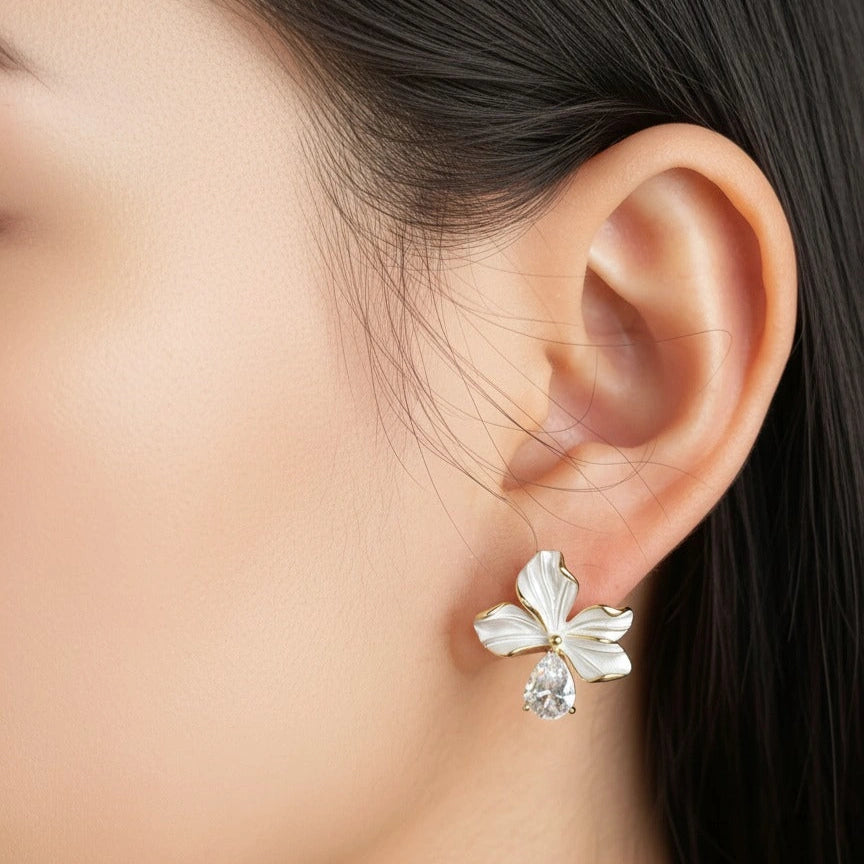 Model wearing gold white enamel bloom flower earrings
