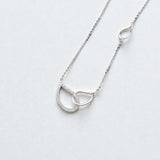 Pavé interlocking silver circle necklace on white background