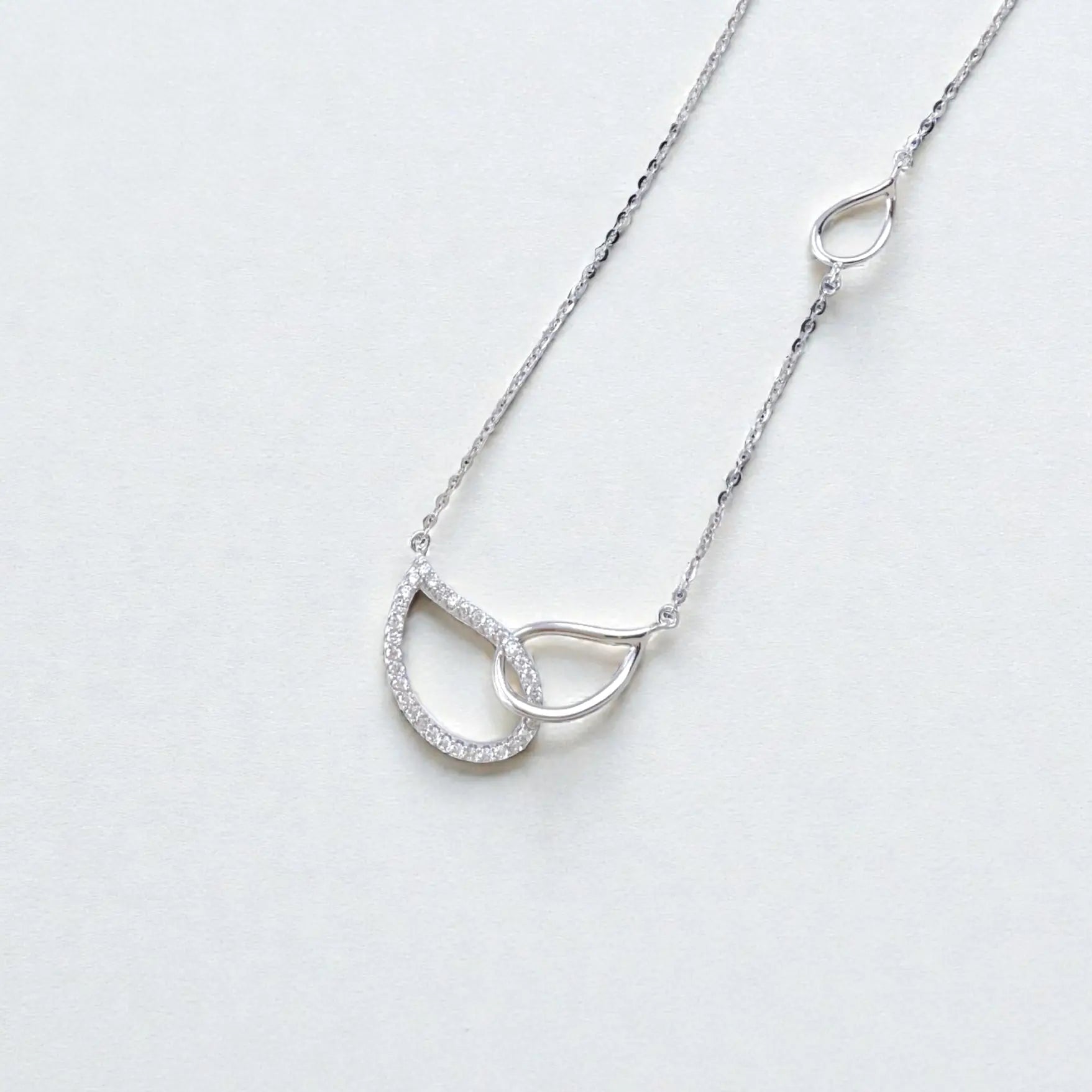 Pavé interlocking silver circle necklace on white background