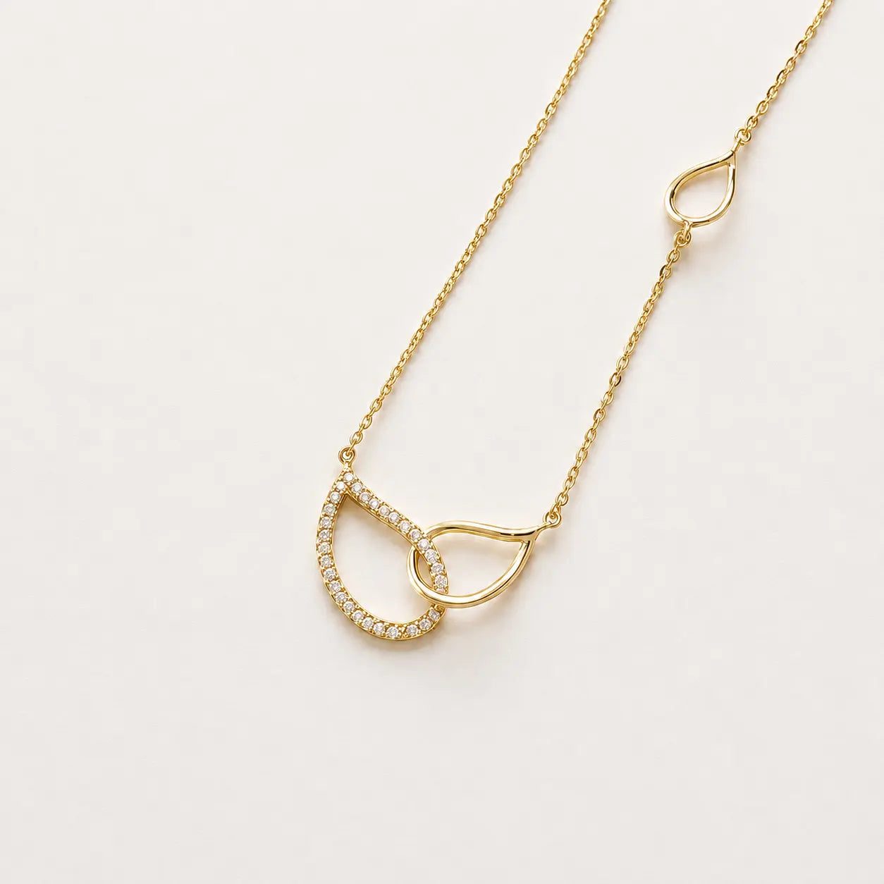 Gold necklace with a unique pendant on a light gray background