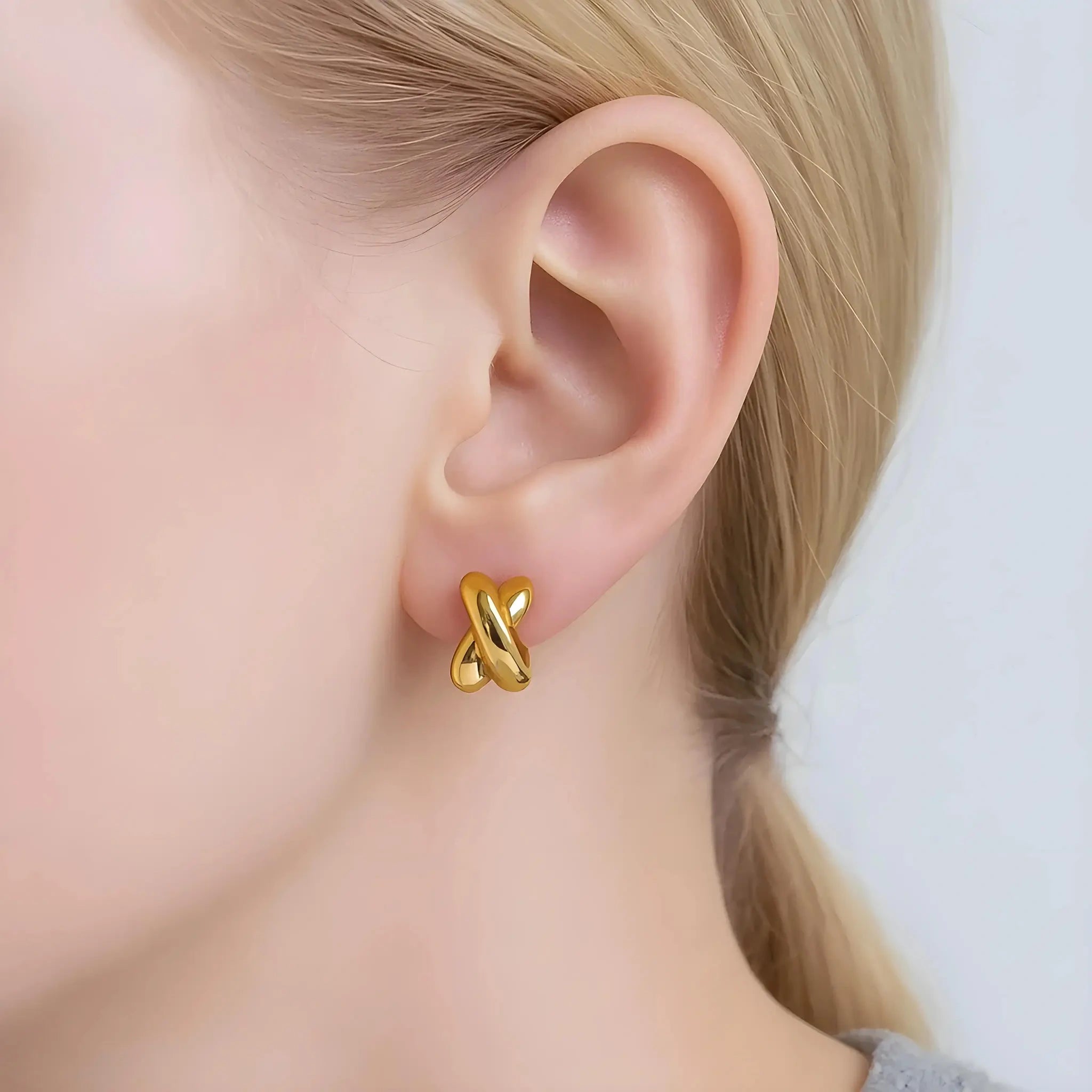 Model wearing hypoallergenic gold vermeil everyday gold twist huggie hoop earrings by Hermin
