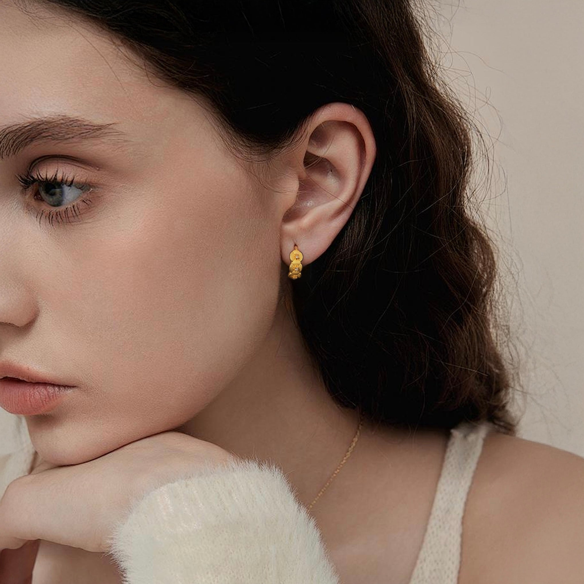 Close-up of Hermin's Tulle Textured Gold Woven Sparkle Huggie Hoops in 18k gold vermeil over sterling silver, crafted for elegance and durability
