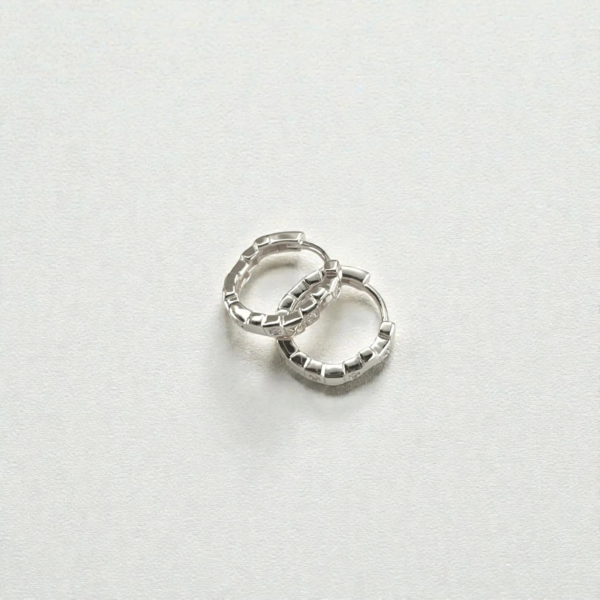Petite geometric huggie hoops in sterling silver finish with pavé crystals
