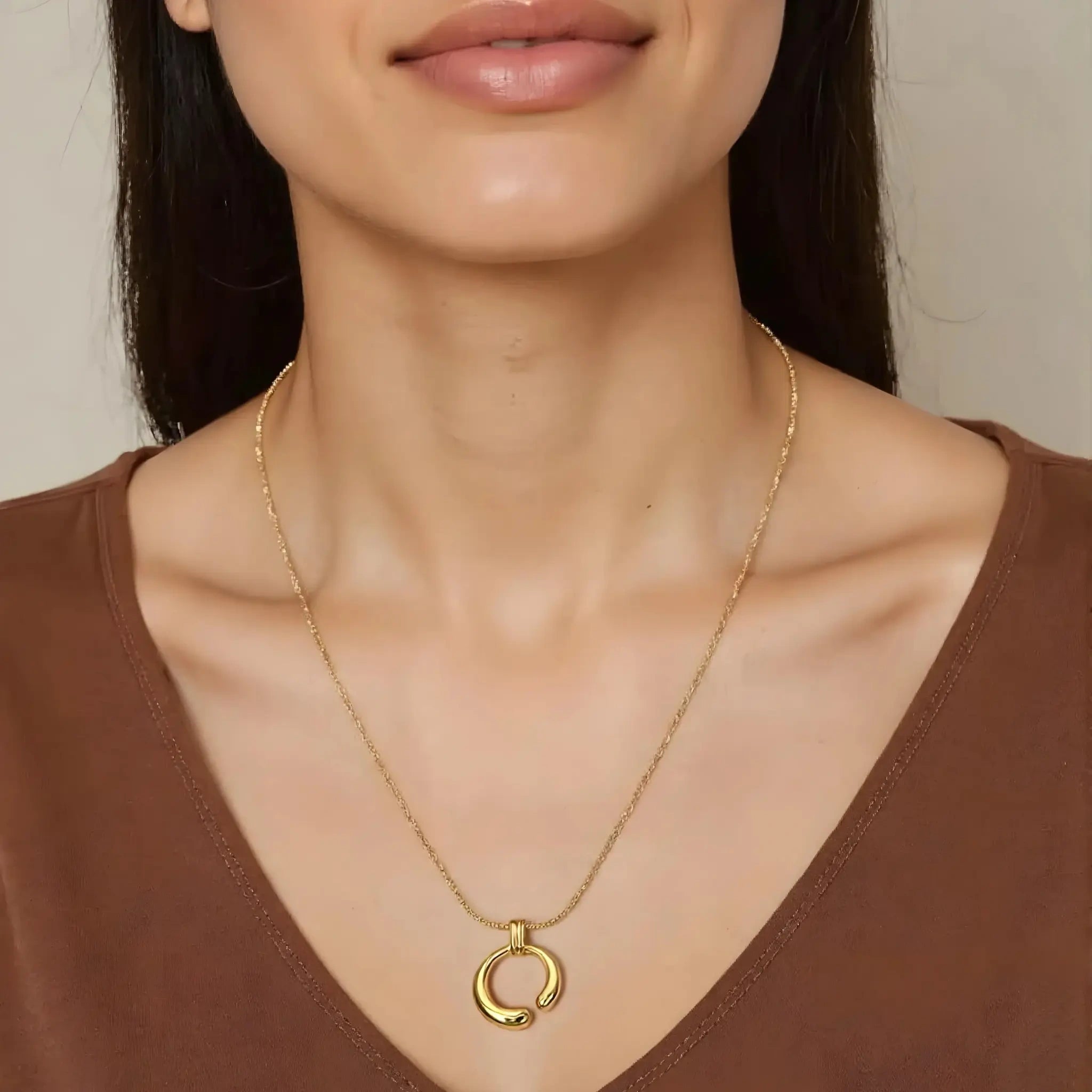 Model wearing hypoallergenic gold vermeil curved circle pendant necklace
