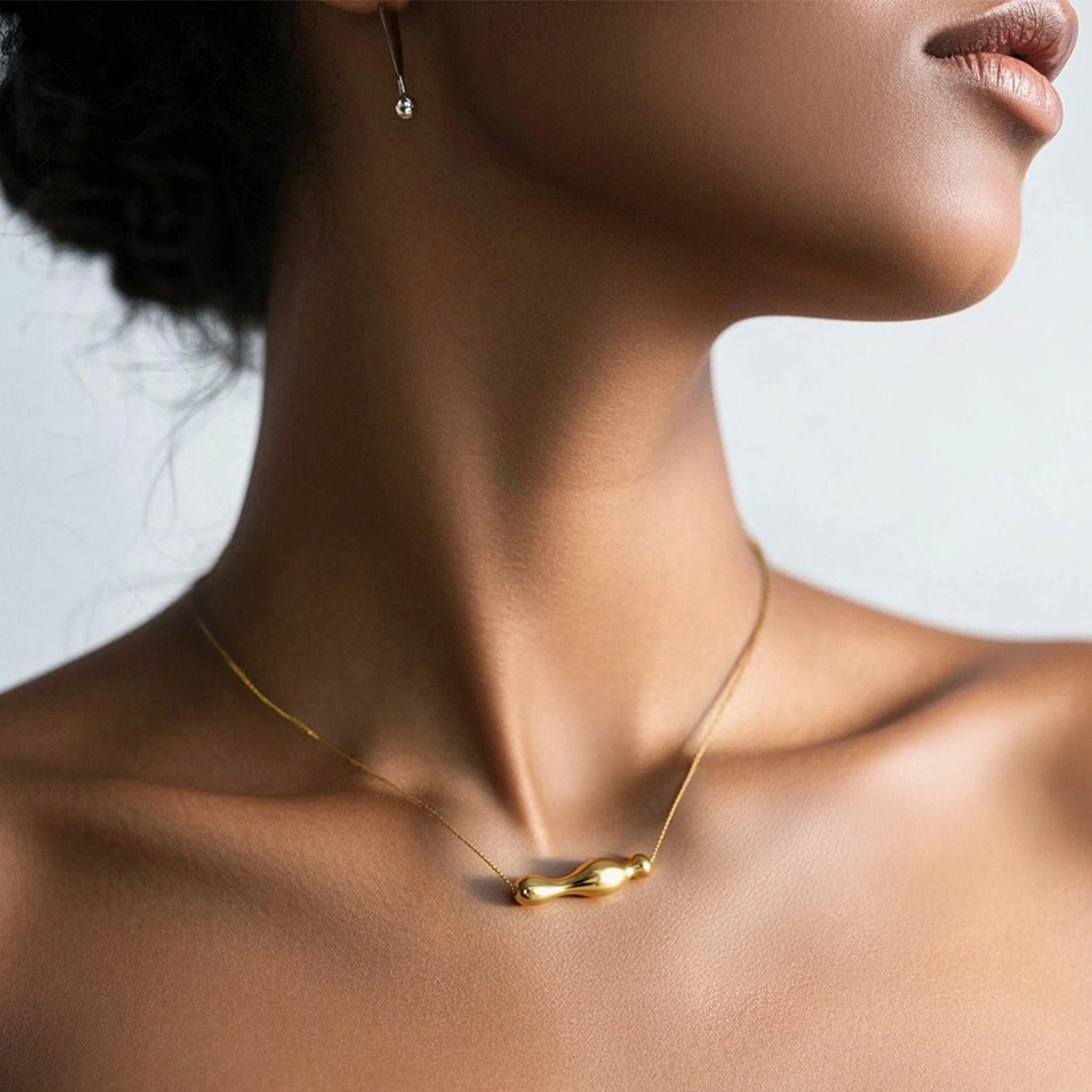 Model wearing hypoallergenic gold vermeil kinetic bar pendant necklace
