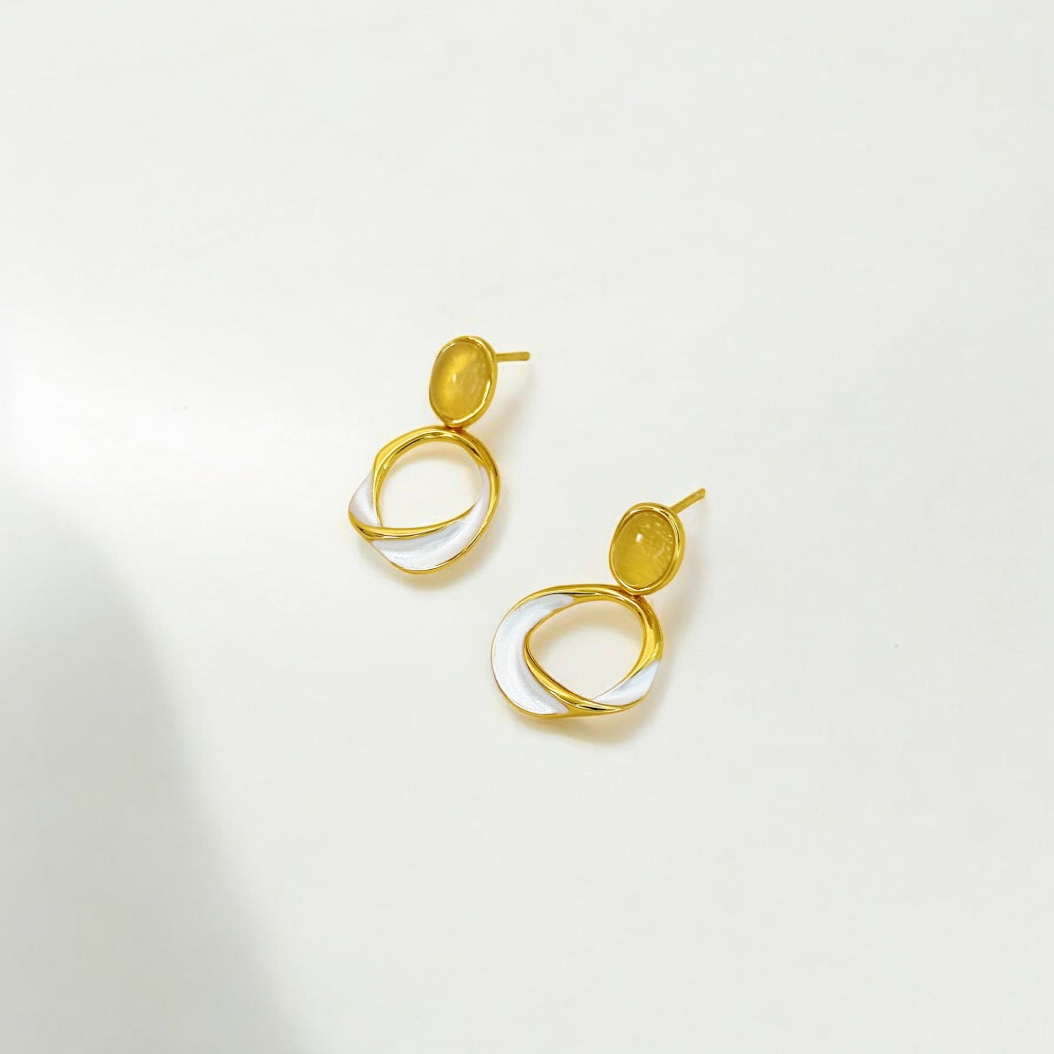Gold and silver earrings on a light gray background