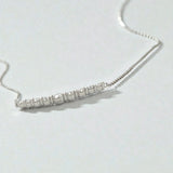 Dainty silver crescent necklace with graduated moissanite bar, modern minimalist jewelry