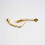 Close-up of Aurelia two-way gold pavé drop earrings showing curved double-drop silhouette and CZ pavé sparkle in 18K gold vermeil