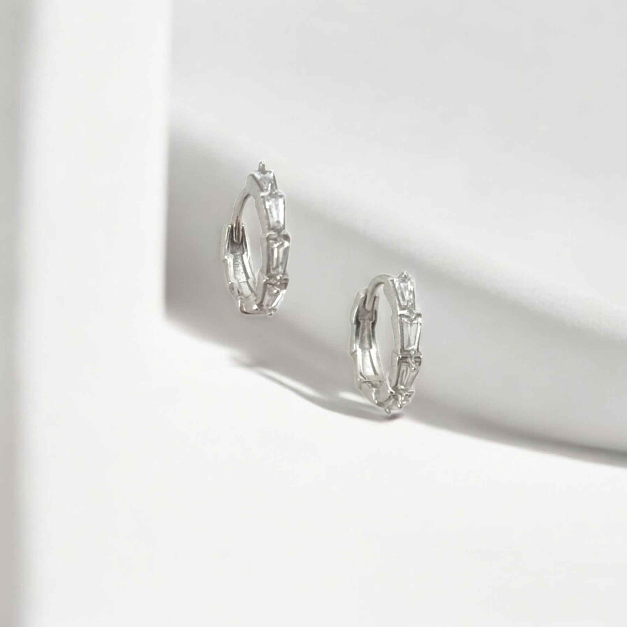 Tapered Baguette Silver Huggie Hoops made from sterling silver with rhodium finish, minimalist design by Hermin Jewelry