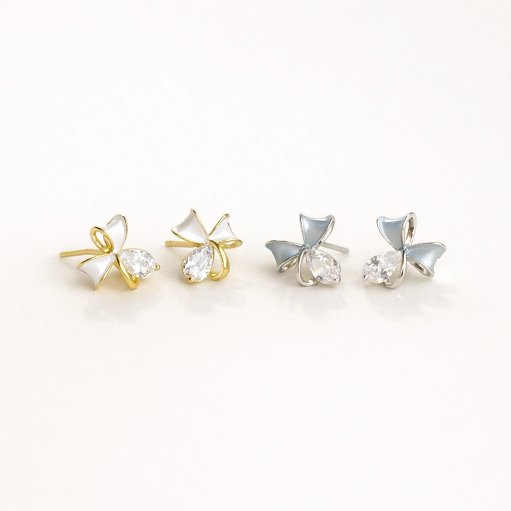 Dainty gold bow earrings with white enamel and crystals, hypoallergenic studs