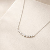Sterling silver crescent bar necklace for women with graduated moissanite stones