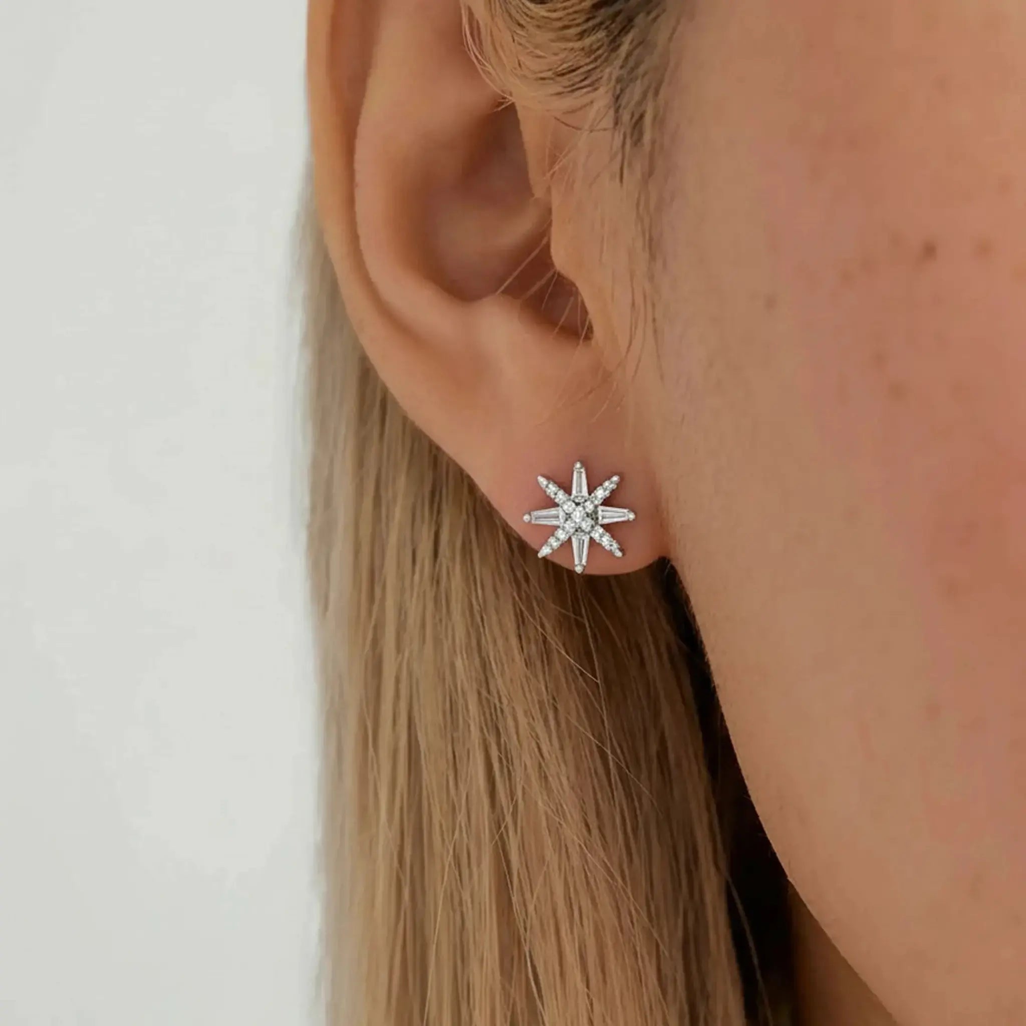 Model wearing hypoallergenic sterling silver north star stud earrings with rhodium vermeil
