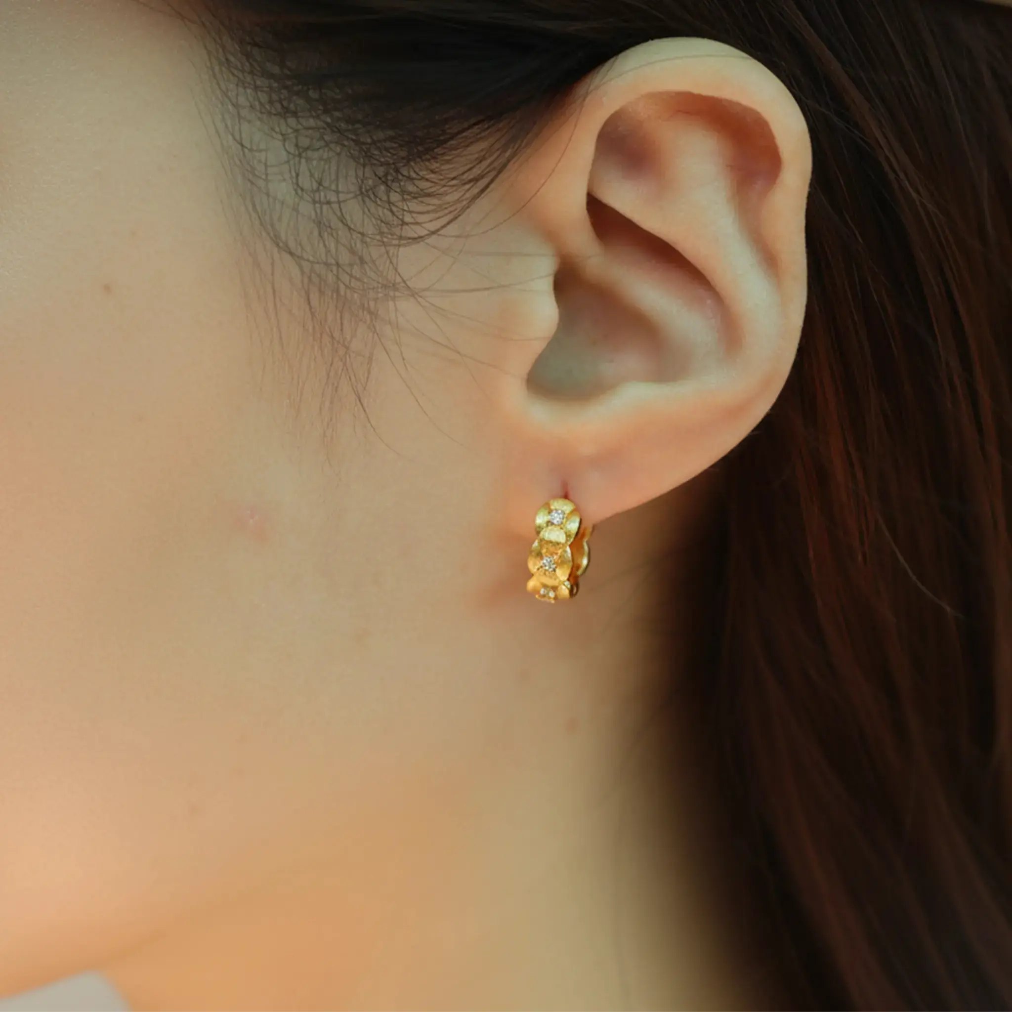 Model wearing hypoallergenic gold vermeil tulle textured woven sparkle huggie hoop earrings
