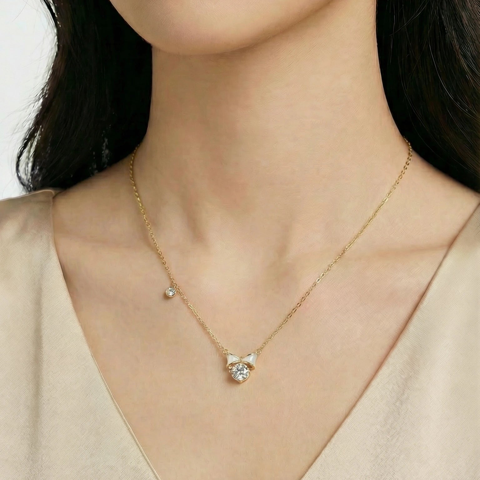 Feminine white enamel bow necklace in gold, perfect for layering or wearing alone as a dainty accent piece