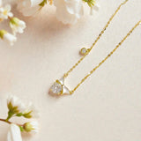 Gold petite bow pendant necklace with white enamel and crystals