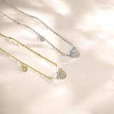 Two necklaces with bow-shaped pendants on a soft beige background