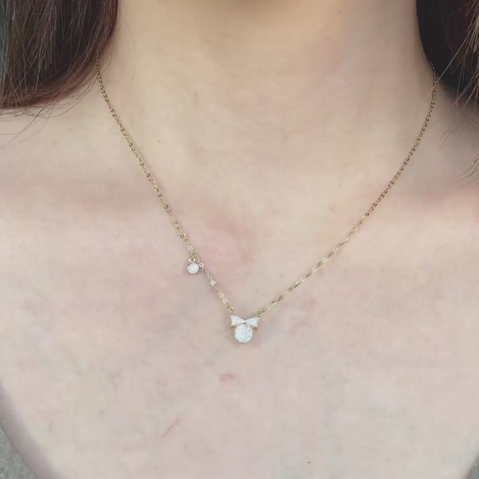 A petite white enamel bow finished with a shimmering 6mm CZ—sparkly enough to feel special, yet dainty enough for effortless daily wear. Crafted in S925 sterling silver with luminous 14K gold vermeil for a timeless, mirror-bright shine.
